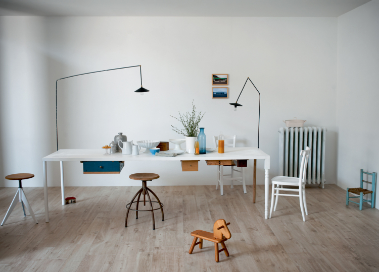 Helles Arbeitszimmer mit weißem Tisch, mehreren Stühlen auf hellem Holzoptik-Boden.