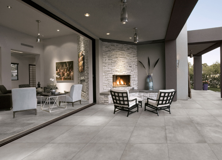 Wohnraum und Terrasse mit grauen Fliesen in Betonoptik, moderne Sitzecke mit Kamin