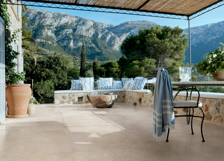 Terrasse im mediteranen Stil mit Bergpanorama, am Boden dezente, beige Außenkeramik.