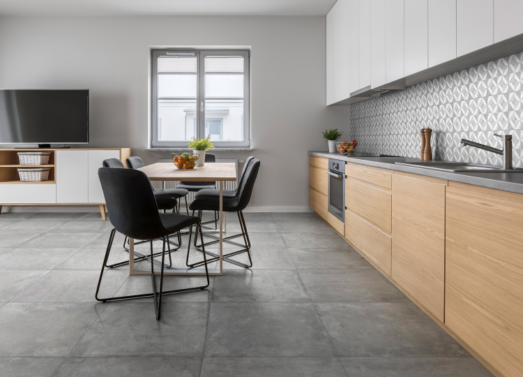 Graue Großformat Fliesen in moderner Küche mit hellem Holz und Esstisch mit dunklen Stühlen